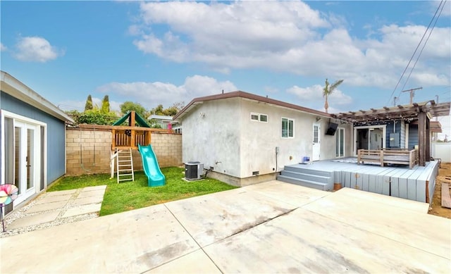 rear view of property featuring a playground, fence, a pergola, central AC, and a patio