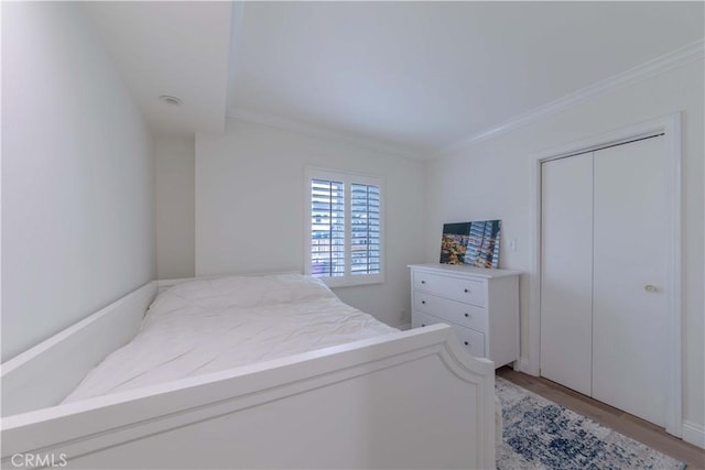 bedroom with crown molding and light wood-style flooring