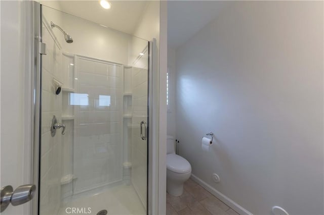 full bathroom featuring a shower stall, toilet, and baseboards