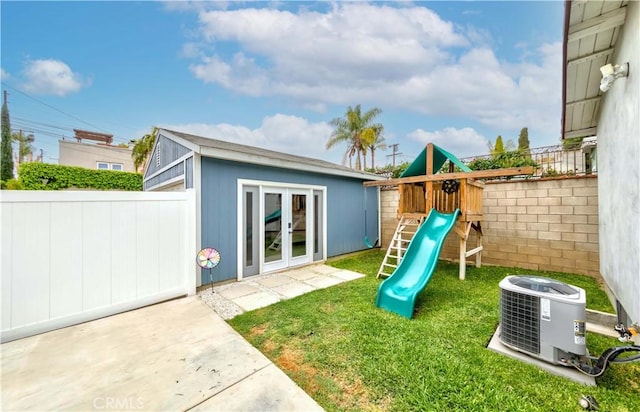 view of jungle gym featuring an outdoor structure, fence, a yard, and cooling unit