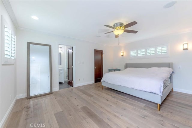 bedroom featuring light wood-style floors, crown molding, baseboards, and connected bathroom