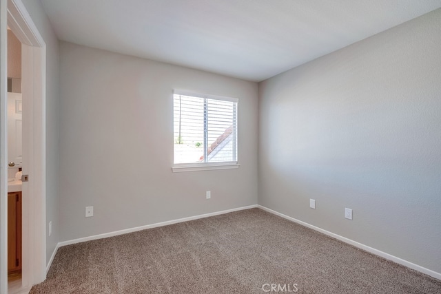 unfurnished room with light carpet and baseboards