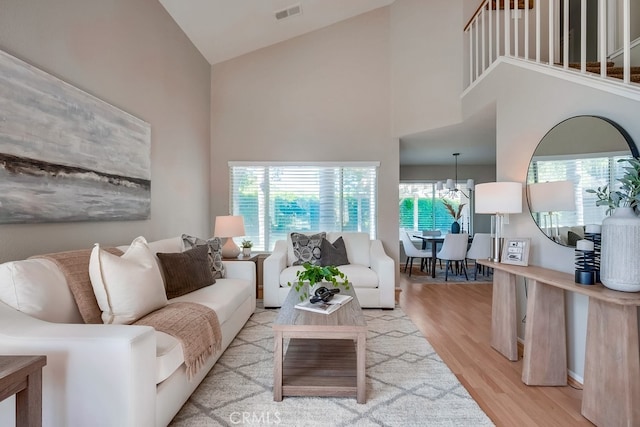 living room featuring high vaulted ceiling, light wood-style flooring, and healthy amount of natural light