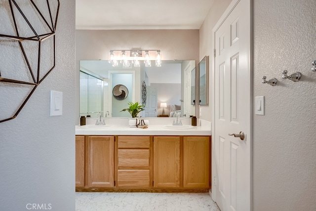 ensuite bathroom with a shower stall, double vanity, and a textured wall