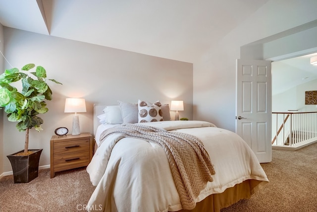 carpeted bedroom featuring lofted ceiling and baseboards