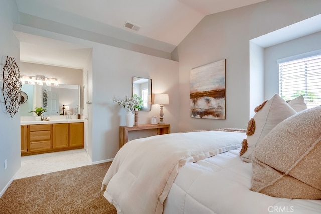bedroom with light colored carpet, connected bathroom, baseboards, and vaulted ceiling
