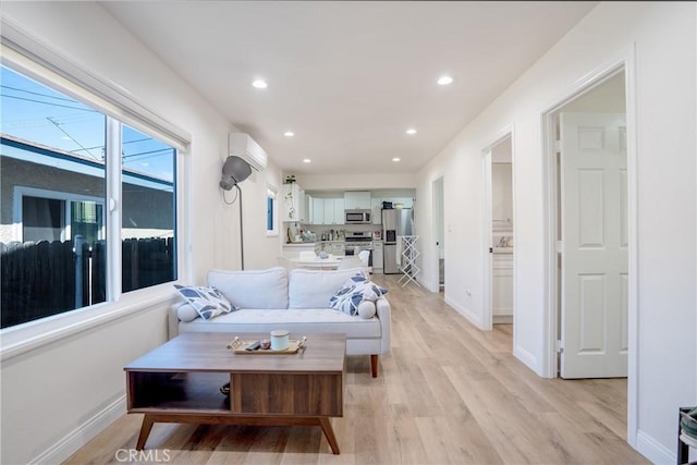 living room featuring plenty of natural light, recessed lighting, light wood-style floors, and an AC wall unit