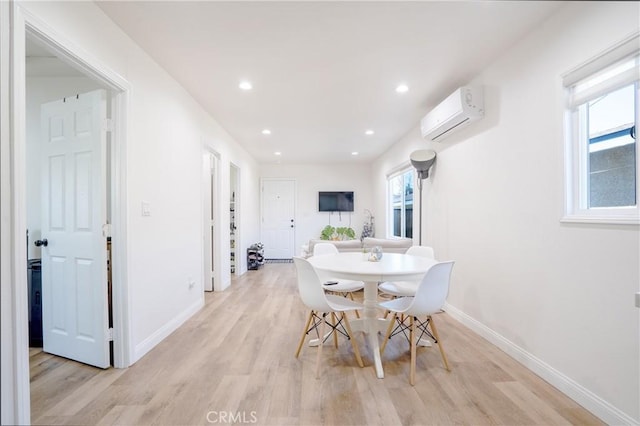 dining room with a wall mounted AC, light wood finished floors, baseboards, and recessed lighting