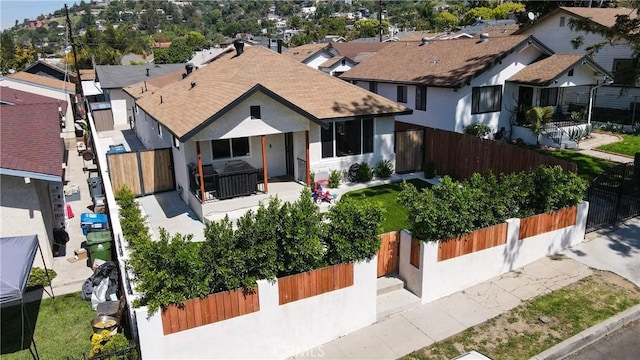 view of front of home with fence, a residential view, stucco siding, and roof with shingles