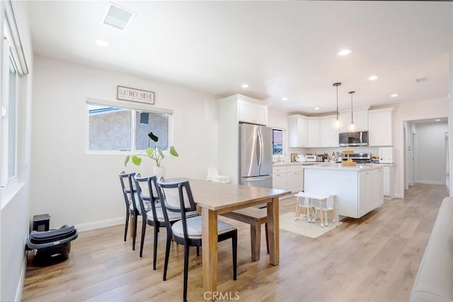 dining room featuring light wood-type flooring, baseboards, visible vents, and recessed lighting