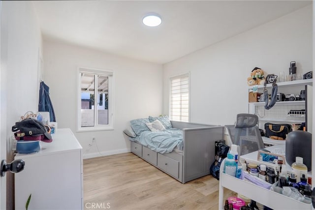bedroom featuring light wood-style floors and baseboards