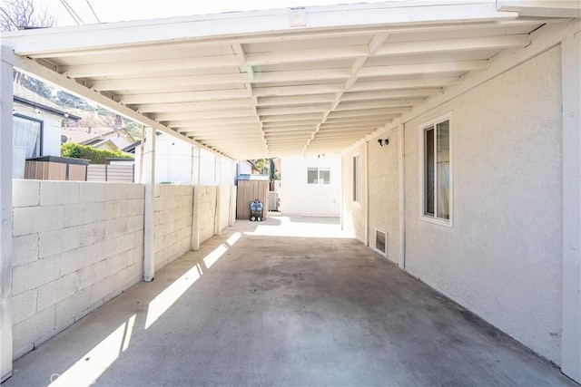 view of patio featuring a carport, fence, and visible vents