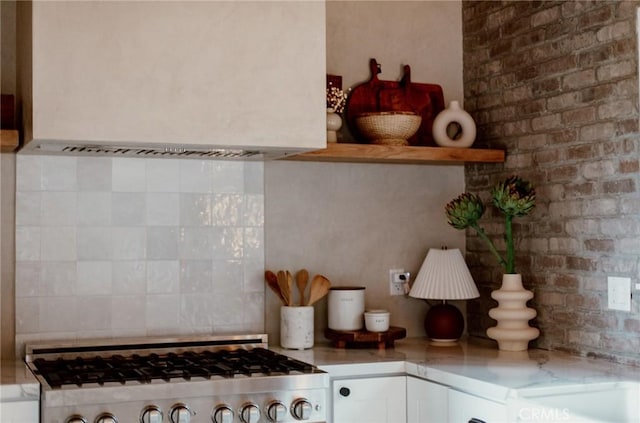 kitchen featuring decorative backsplash, light countertops, and white cabinets