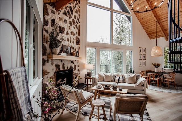 living room with high vaulted ceiling, a stone fireplace, wood ceiling, wood finished floors, and beam ceiling
