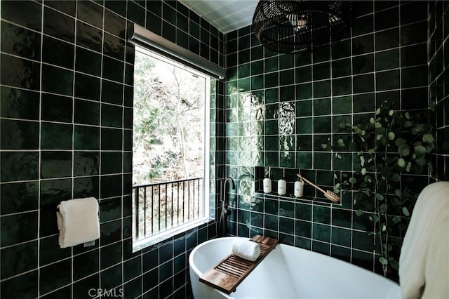 bathroom featuring a freestanding tub and tile walls