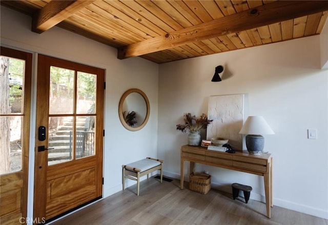 entryway with beamed ceiling, baseboards, wooden ceiling, and wood finished floors