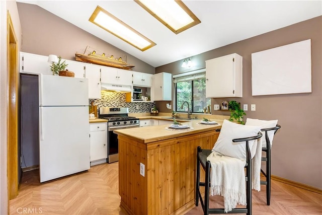 862 Strawberry Peak Rd, Twin Peaks, CA 92391 - kitchen featuring vaulted ceiling, stainless steel gas stove, a sink, freestanding refrigerator, and under cabinet range hood