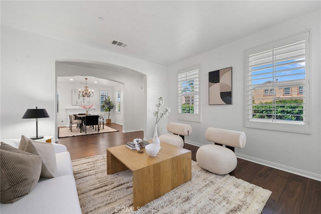 17245 Eagle Canyon Pl, San Diego, CA 92127 - living area featuring arched walkways, dark wood-type flooring, a chandelier, and baseboards