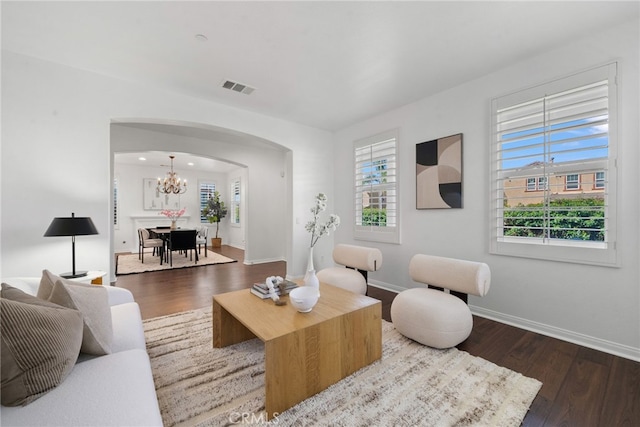 17245 Eagle Canyon Pl, San Diego, CA 92127 - living area featuring arched walkways, dark wood-type flooring, a chandelier, and baseboards