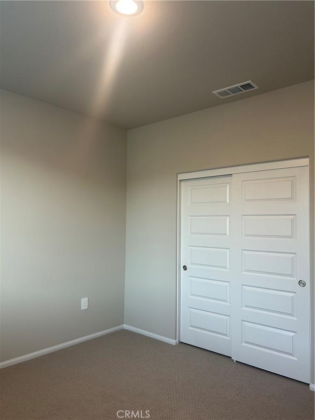 1065 Lumia Cir, Redlands, CA 92374 - unfurnished bedroom with dark colored carpet, visible vents, a closet, and baseboards