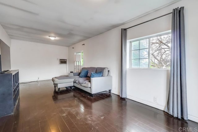 living room featuring baseboards, wood finished floors, and a healthy amount of sunlight