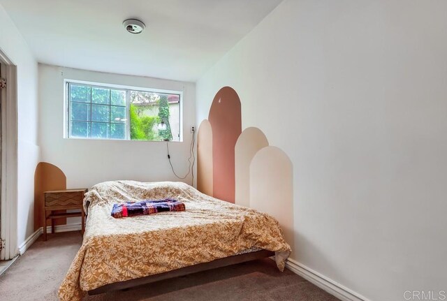 bedroom featuring baseboards and carpet
