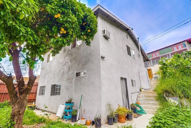 view of property exterior with fence and stucco siding