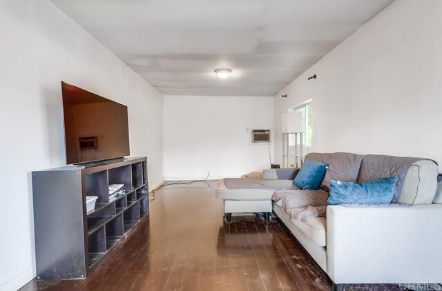 living room featuring wood finished floors and an AC wall unit