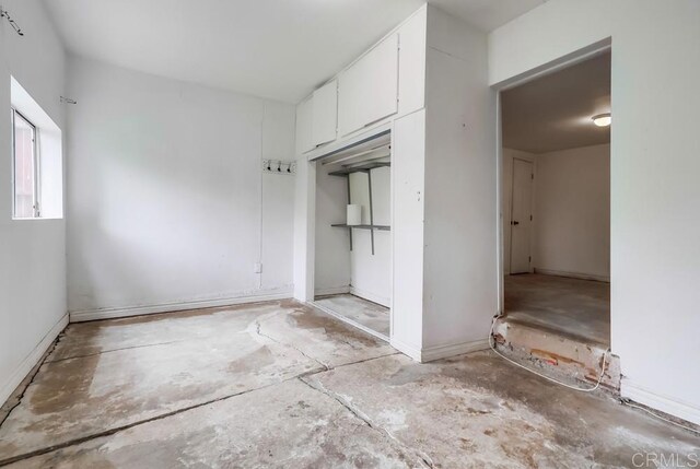 interior space featuring unfinished concrete floors and a closet