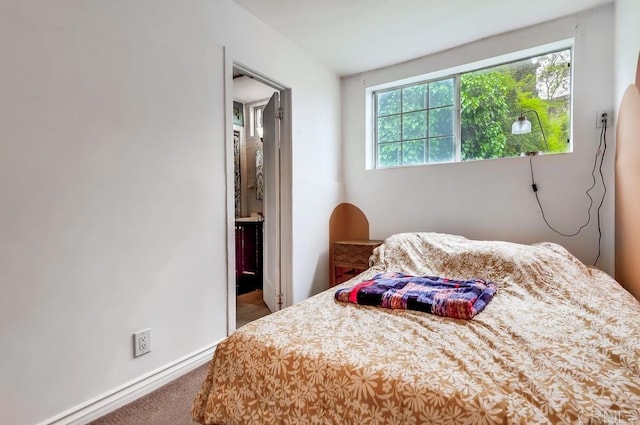 bedroom featuring carpet flooring, connected bathroom, and baseboards