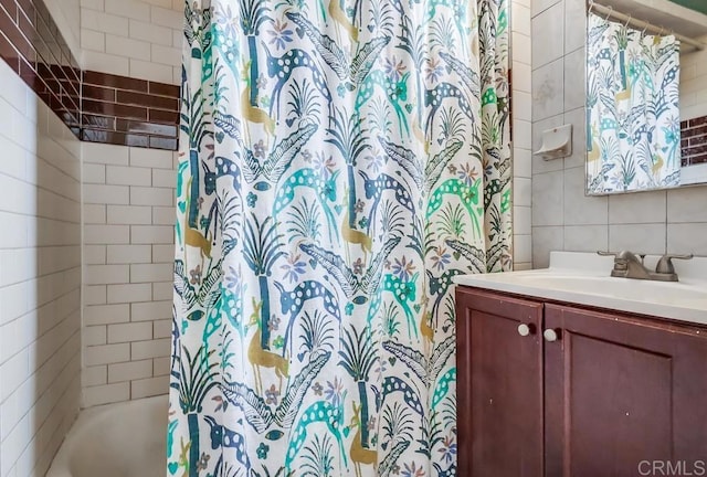 bathroom featuring tile walls, shower / bathtub combination with curtain, and vanity