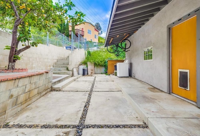 view of patio with washer / dryer and fence