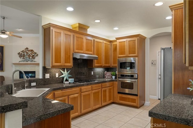 2327 Via Calle Ct, Durham, CA 95938 - kitchen with light tile patterned floors, a sink, appliances with stainless steel finishes, under cabinet range hood, and decorative backsplash