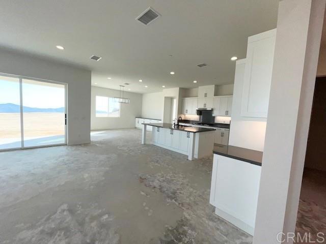 kitchen with visible vents, white cabinets, dark countertops, unfinished concrete flooring, and recessed lighting