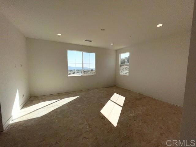 spare room with carpet floors, recessed lighting, and visible vents