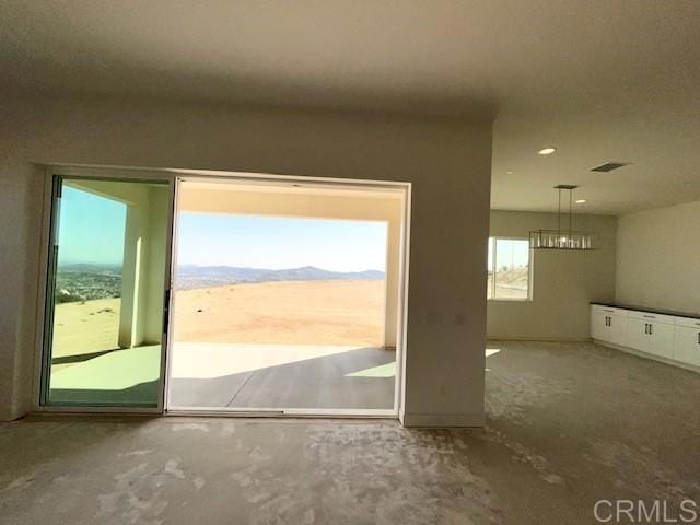 doorway to outside with recessed lighting, visible vents, and concrete flooring