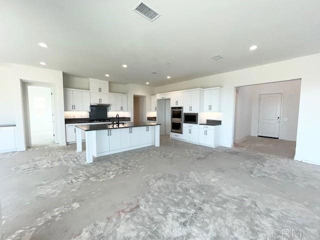 kitchen with white cabinetry, visible vents, dark countertops, and recessed lighting