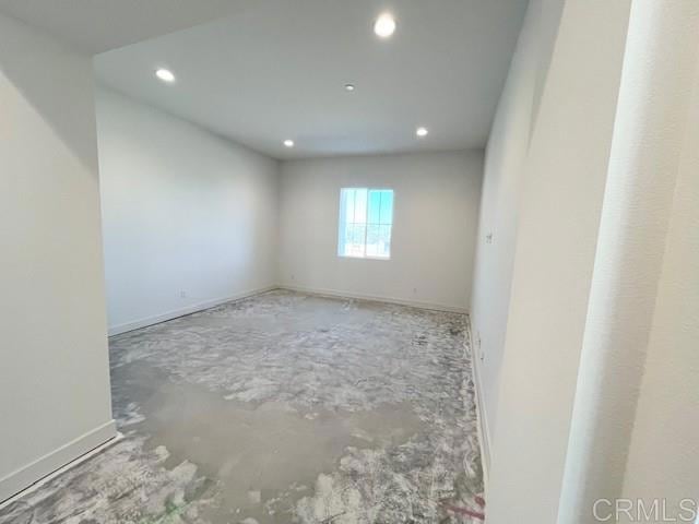 unfurnished room with baseboards and recessed lighting