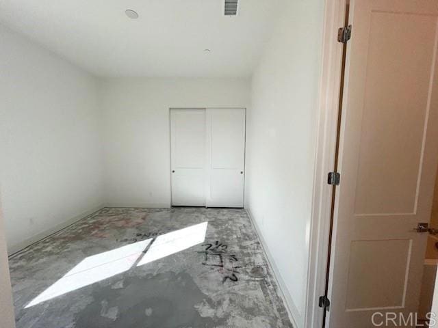 unfurnished bedroom featuring a closet, baseboards, and visible vents
