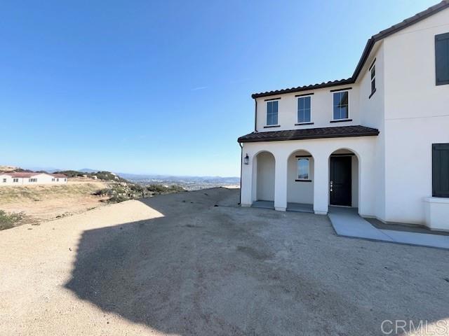 view of front of home featuring a tile roof and stucco siding