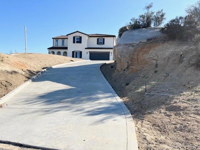 view of front of home featuring a garage, driveway, and stucco siding
