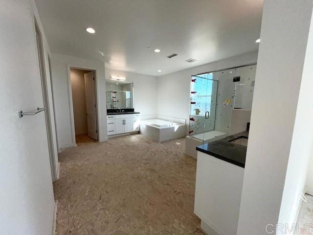 bathroom with vanity, a bathtub, and recessed lighting