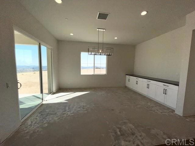 unfurnished dining area featuring visible vents, recessed lighting, and a notable chandelier