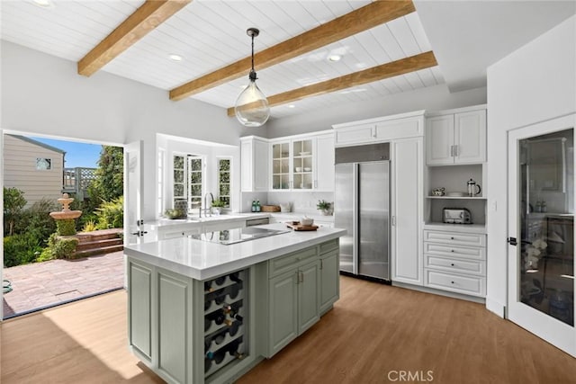 kitchen featuring a center island, light countertops, light wood-style floors, stainless steel built in refrigerator, and white cabinetry