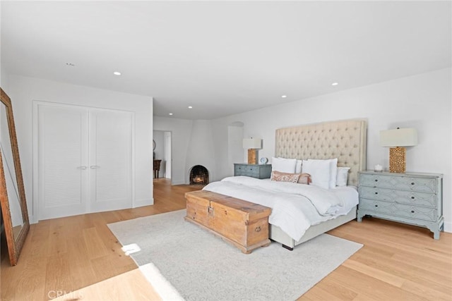 bedroom featuring light wood-style floors, recessed lighting, and a closet