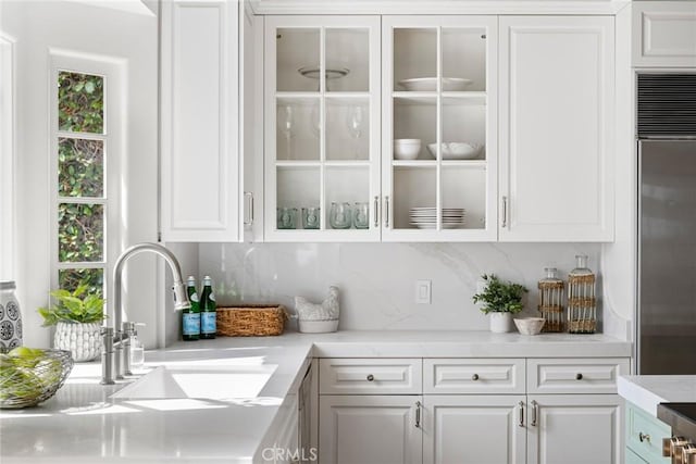 bar with a sink, built in refrigerator, and tasteful backsplash