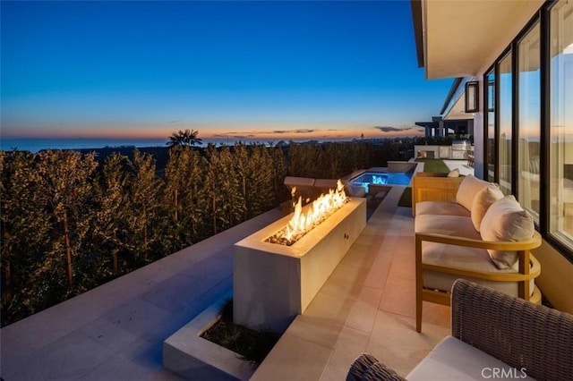 view of patio featuring an outdoor living space with a fire pit and an outdoor pool