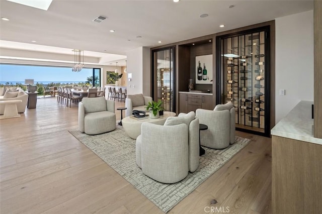 living room featuring visible vents, recessed lighting, an inviting chandelier, and wood finished floors