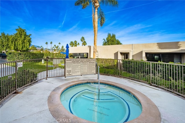view of pool featuring a community hot tub and fence