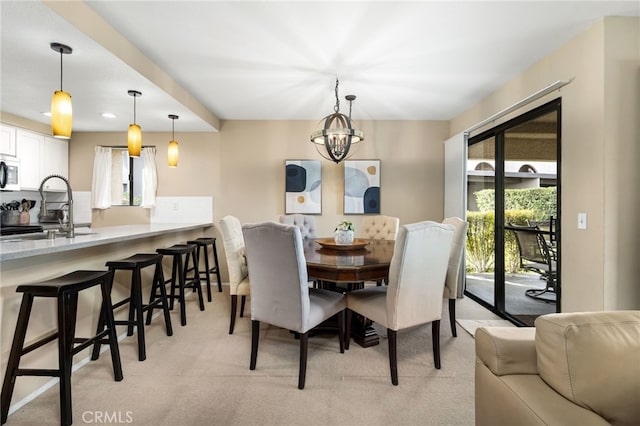 dining space with a chandelier and light carpet